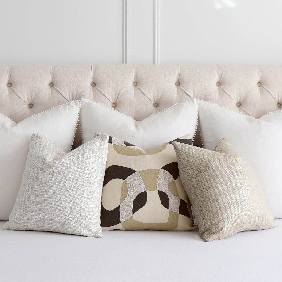 Schumacher Conrad Embroidered Dune Natural Graphic Geometric Designer Throw Pillow Cover with Complementing Throw Pillow on Bed