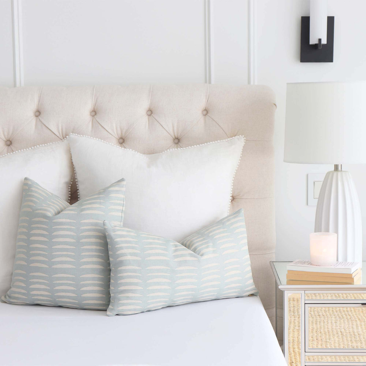 Schumacher Hadiya Williams Luxury Decorative throw pillow cover with wavy hand block pattern on a light blue background on Bed in Bedroom